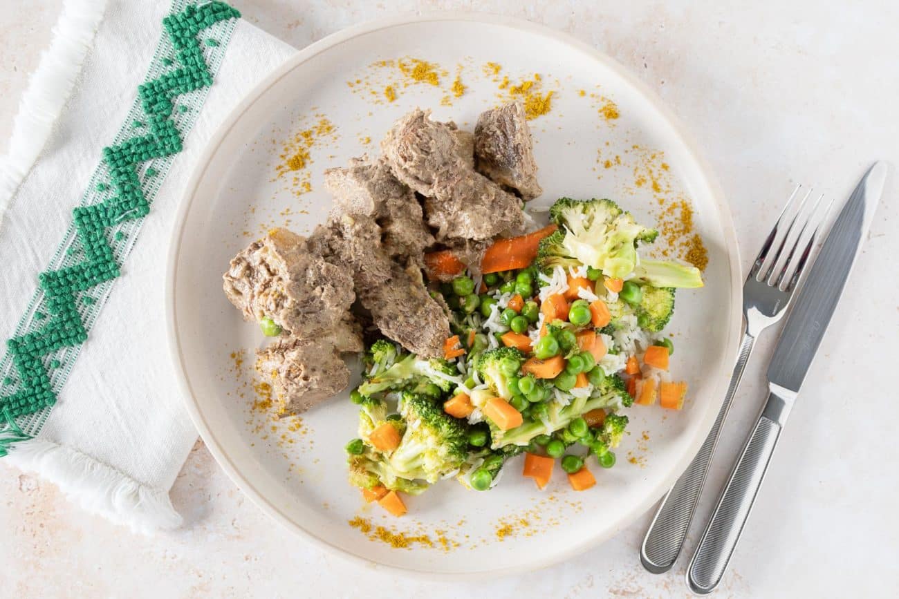 Rindfleisch-Massaman-Curry auf einem Teller mit Gemüse und Reis.