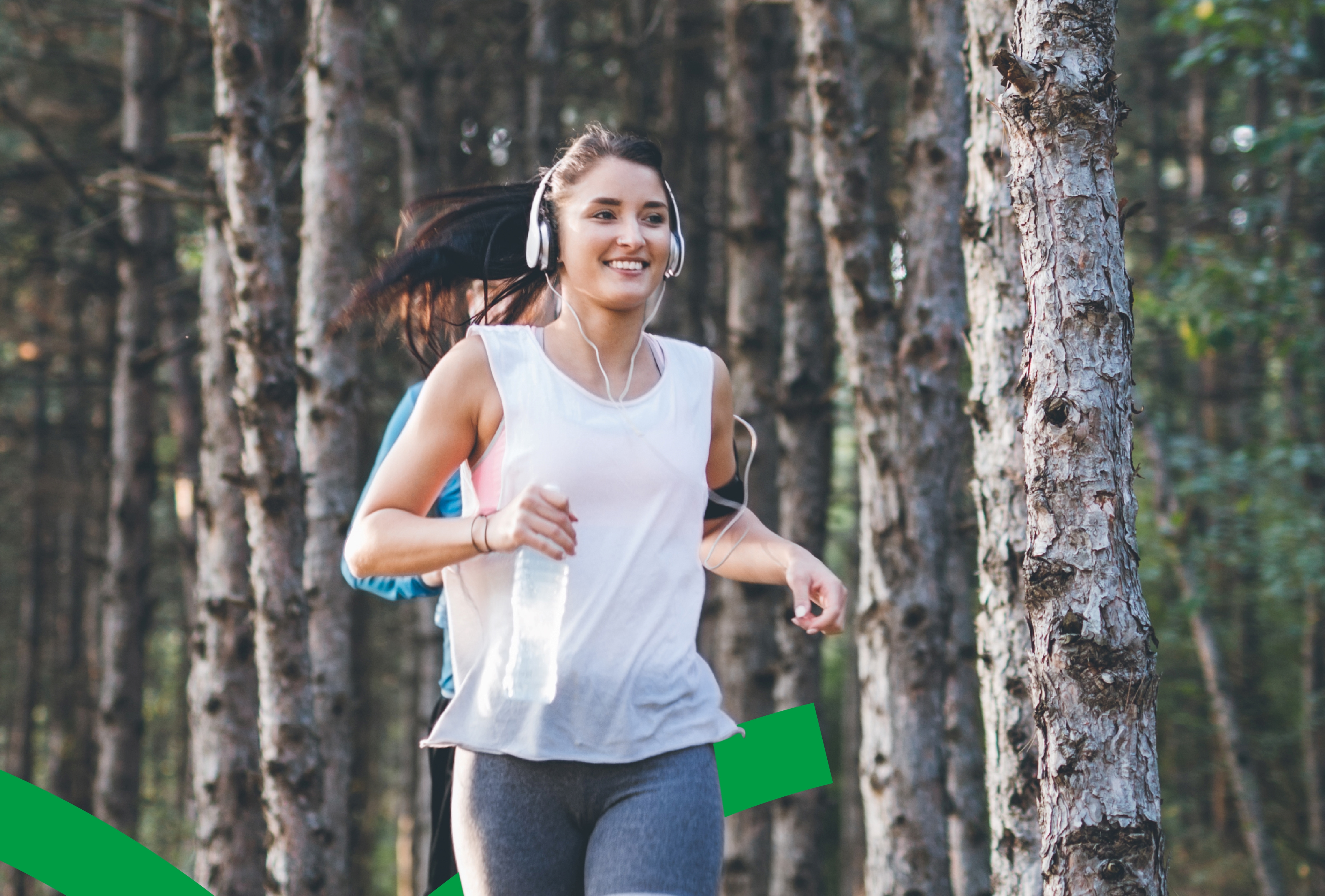 Woman running in forest with headphones
