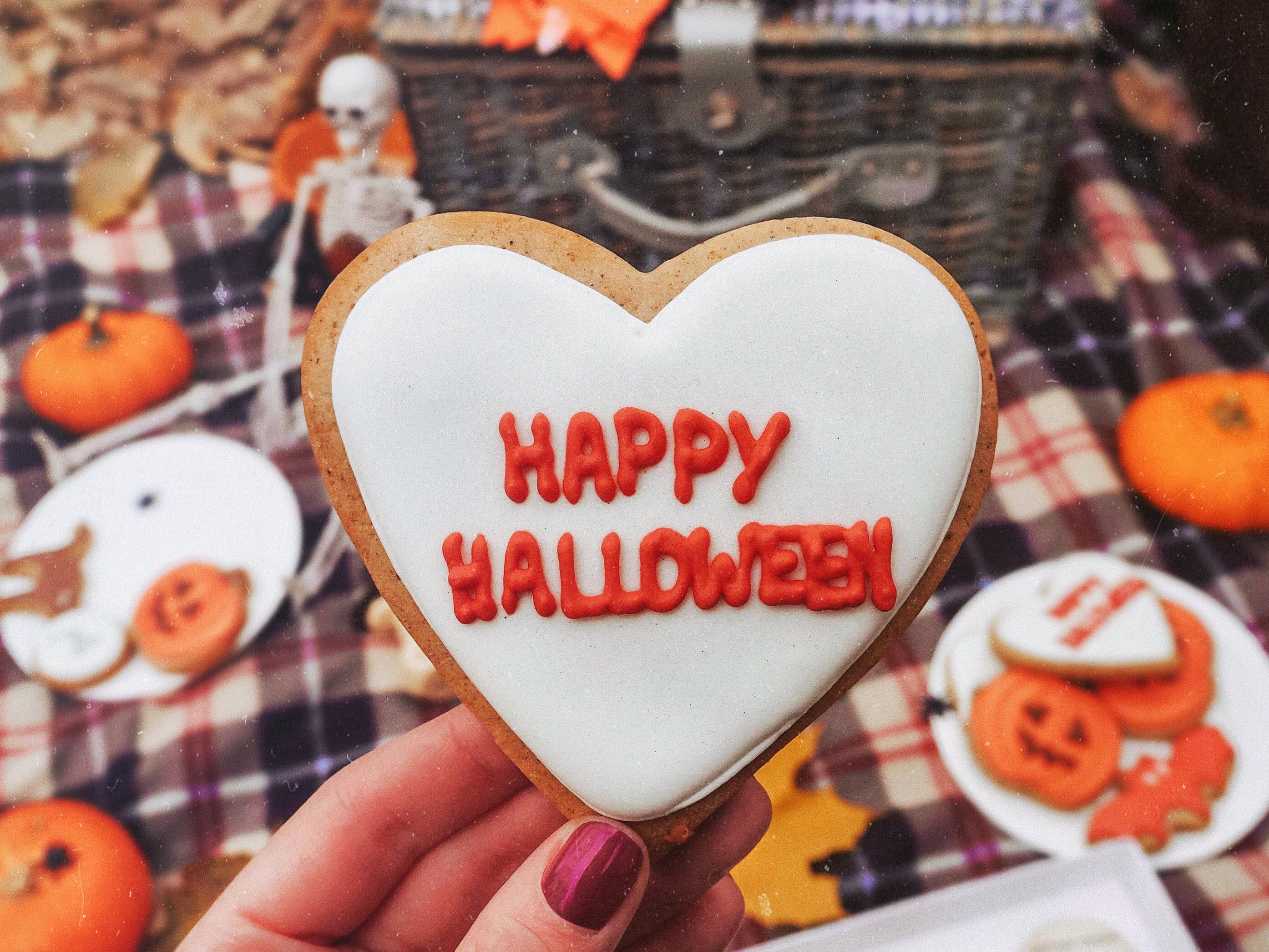eine Hand, die einen Halloween-Keks hält